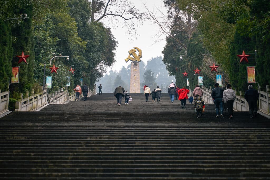 Turyści wspinają się po schodach w Zunyi, by zobaczyć pomnik przypominający wojnę domową. Wycofanie się Zachodu z tego konfliktu pozwoliło wygrać go wspieranym przez ZSRR partyzantom Mao.  Fot. kingkongimagery / Shutterstock.com.
