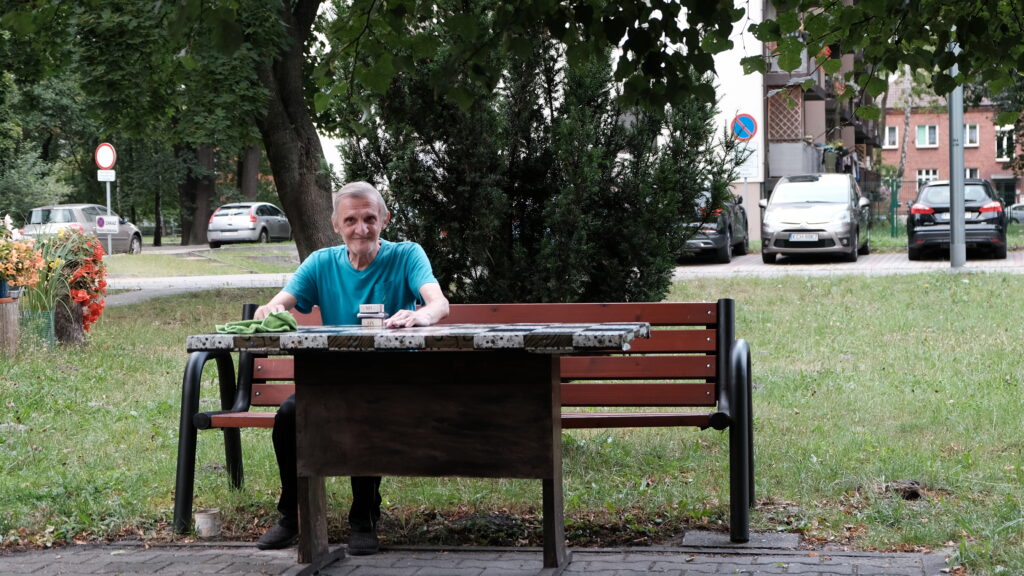 Wszędzie jest pełno stoliczków i ławek, przy których przesiadują ludzie.